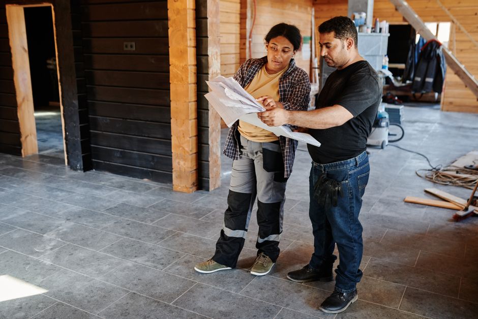 General contractor reviewing blueprints at a construction site